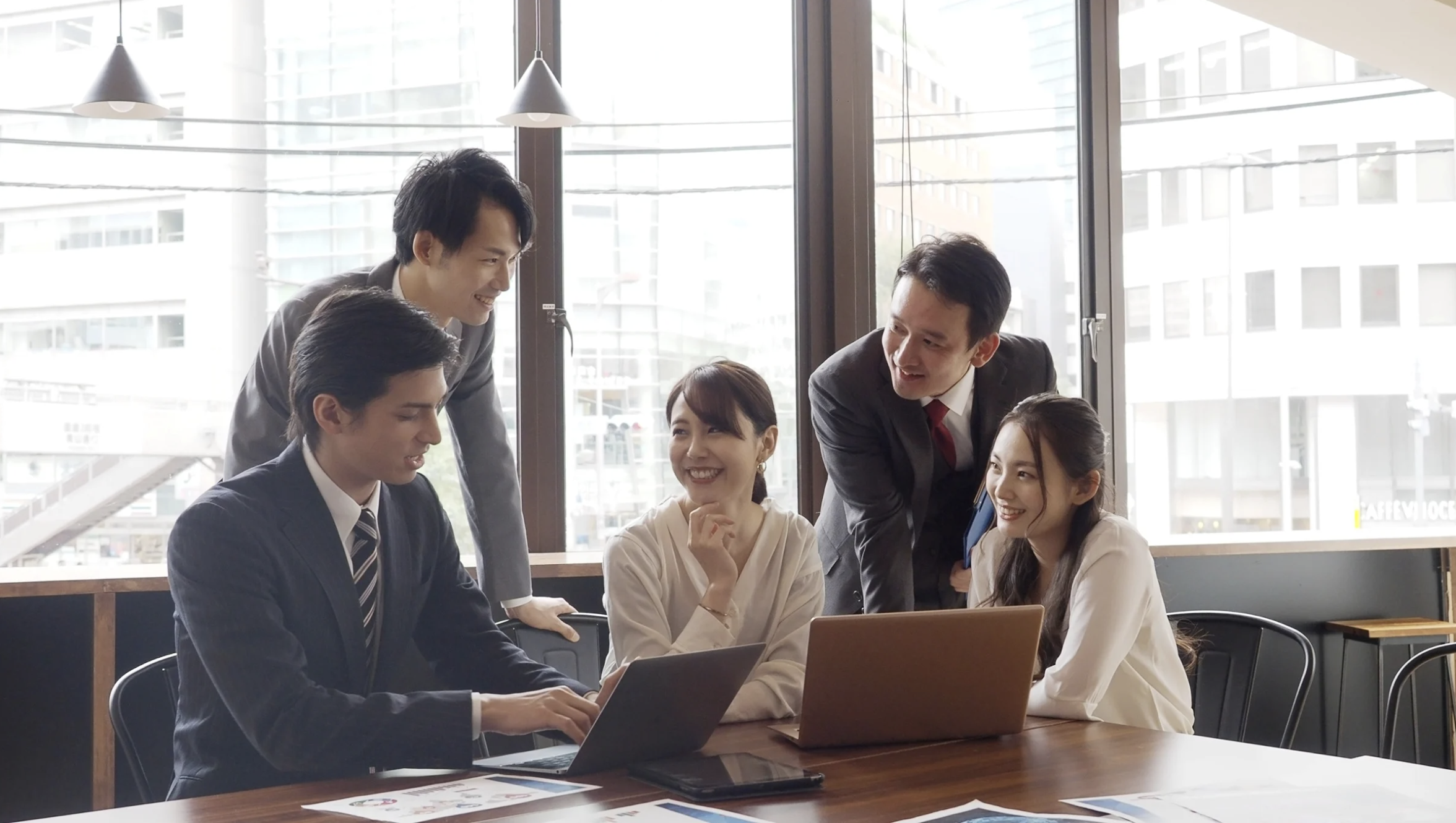 Two business partners shaking hands over documents
